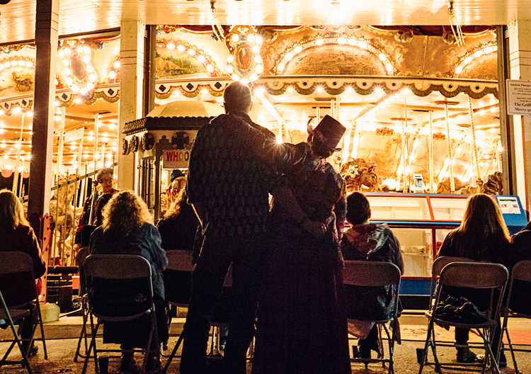 a couple standing and watching the carousel