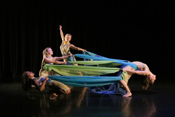 Dancers enveloped in blue and green ribbons