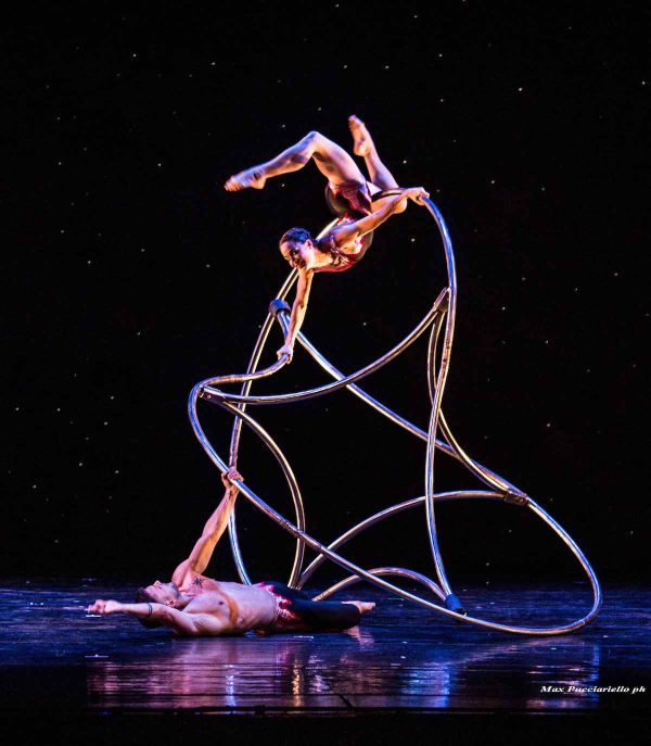 two dancers entwined a metal construct