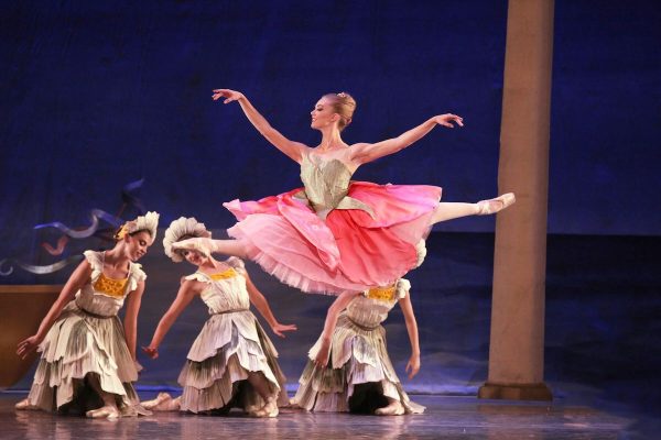 A dancer leaps across the stage