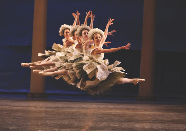 Dancers in flower costumes leap