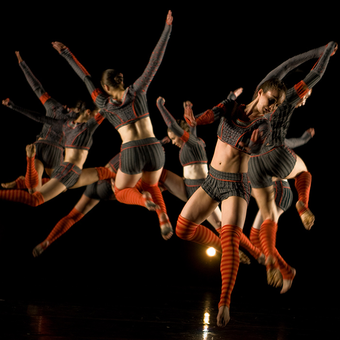 Dancers with red leggings jump