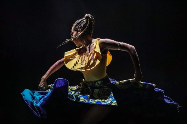 A dancer with a yellow top and glue skirt