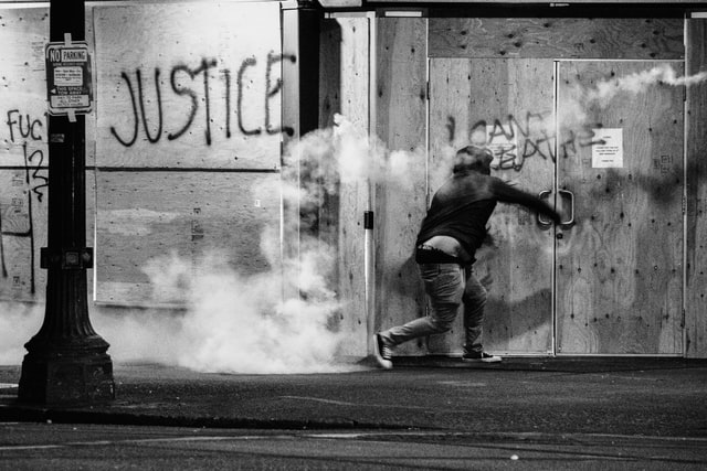 Protester throws tear gas canister back at police during a Black Lives Matter protest in Portland, Oregon. People have been protesting police brutality and the deaths of several members of the Black community - sparked by the recent death of George Floyd.