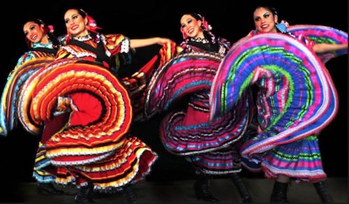 Four female Mexican folkloric dancers swirl multi-colored skirts