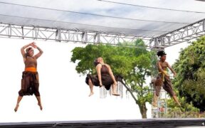 Three women leap on a stage