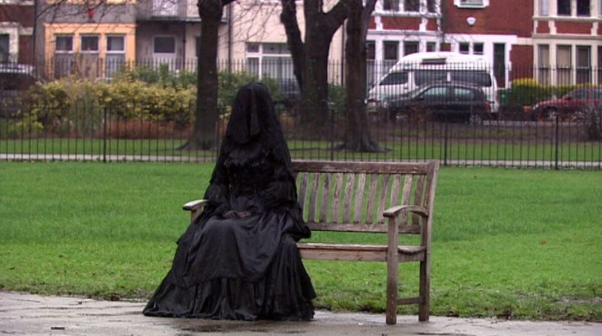 a person dressed in all black, including face cover, like a funeral outfit, in Doctor Who's Silence in the Library/Forest of the Dead