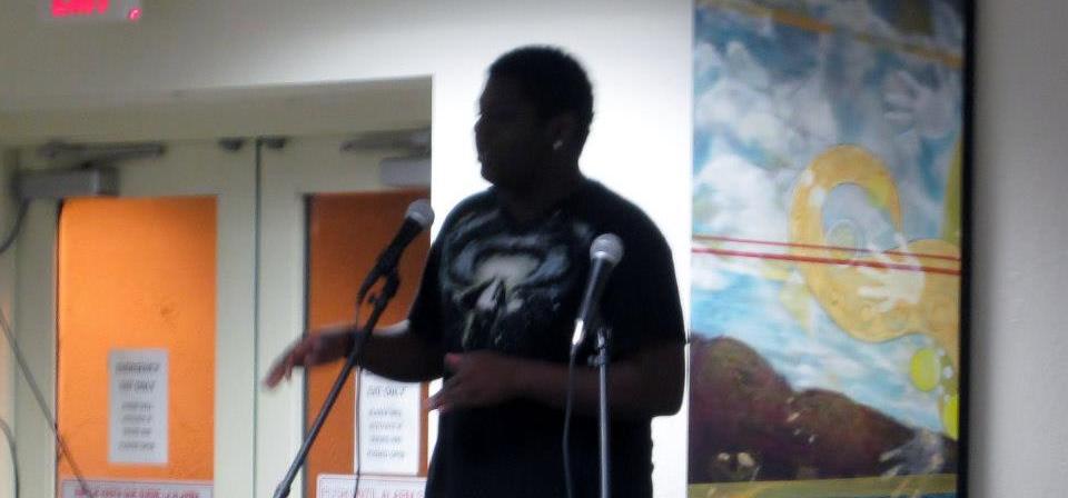 a young black man, Christopher Siders, at the mic performing.