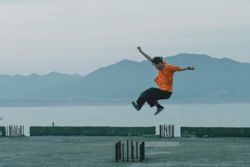 A dancer jumps against a background of water and a mountain