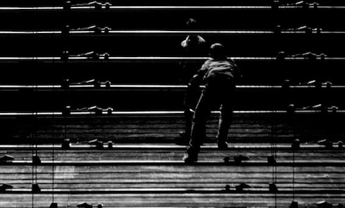 Two figures are separated by slats