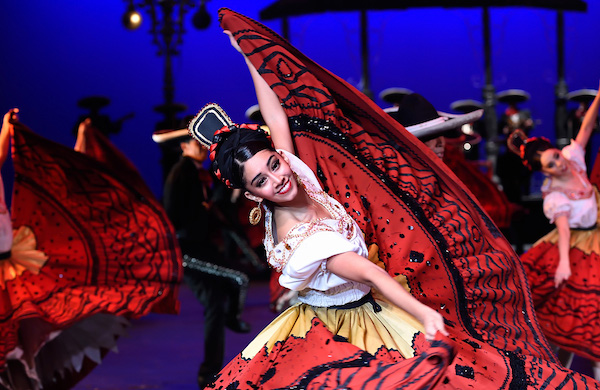 A dancer lifts a long red skirt 