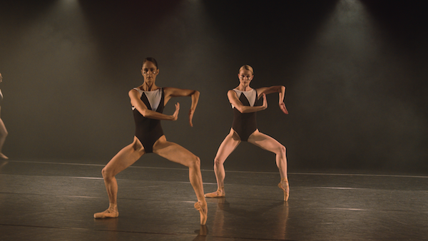 Two dancers in toe shoes strike an angular pose