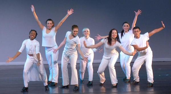 A line of dancers in white pose