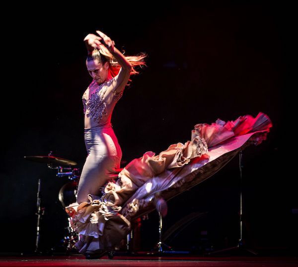 A flamenco dancer swooshes her long skirt 