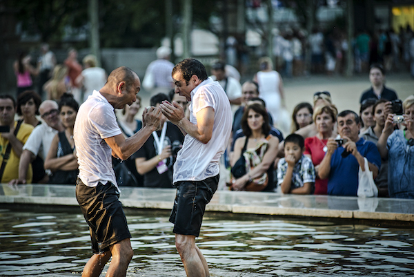 Two men in soaked shirts face each other