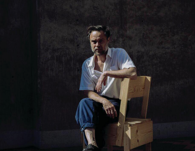 Singer Rodrigo Amarante of Canto en resistencia sits on a chair looking at the camera