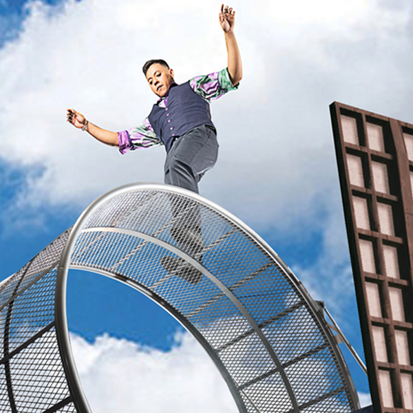 A man stands on a giant wire cylinder