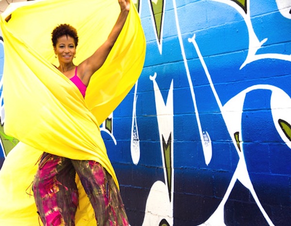 A woman wrapped in bright yellow against a blue background