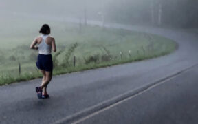 Photo of Lani Scozzari running on a two lane road