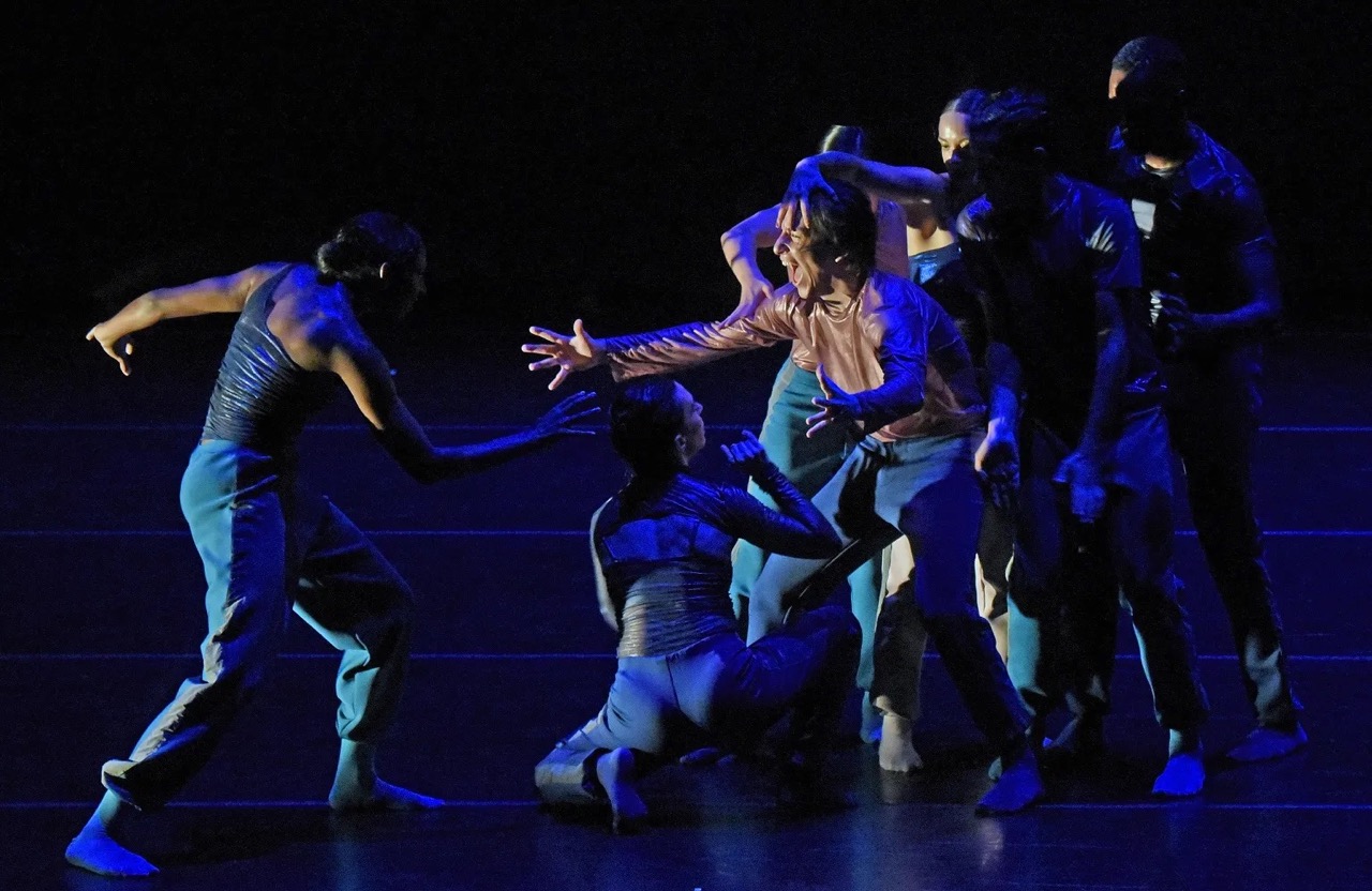 A man in blue lights lunges toward a group stretching a hand toward him