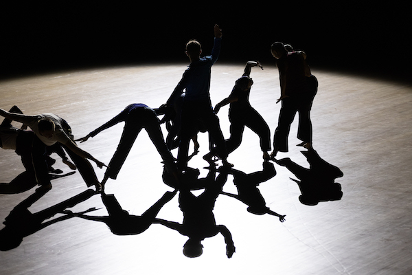 A group of dancers in shadow