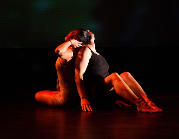 One dancer cradles a second dancer