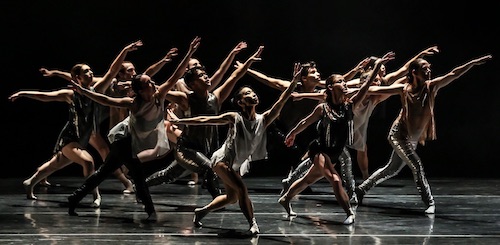 A group of dancers stretch their arms