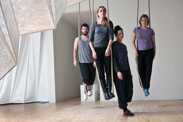 Dancers suspended by ropes