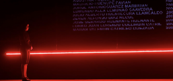 A figure moves against a line of red light