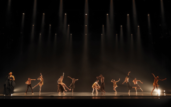 Dancers fill a dark stage