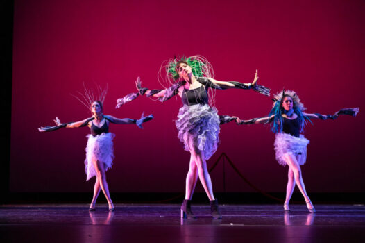 A line of dancers with flexed hands