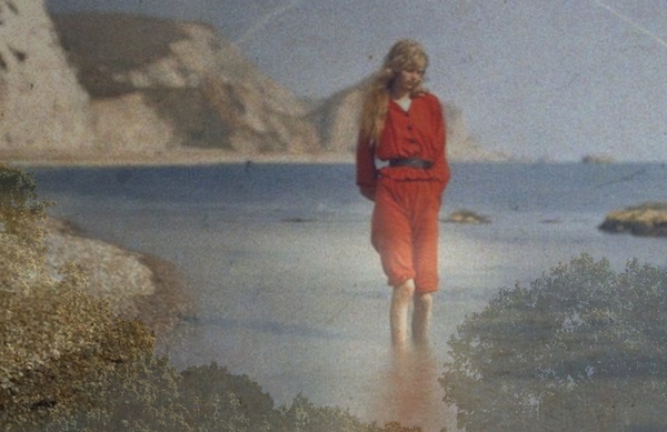 A woman in red walks in the ocean